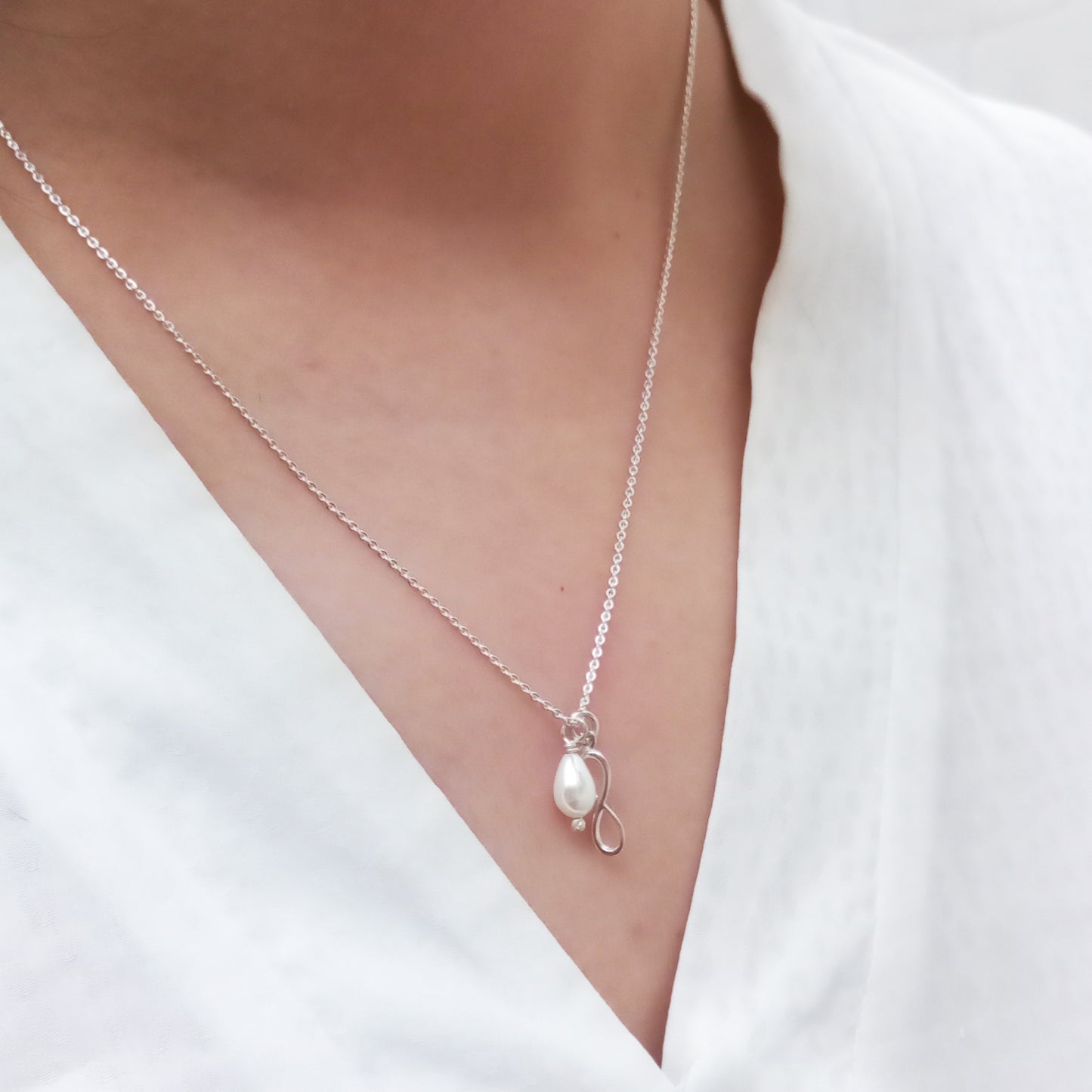 Dije Infinito de plata con perla