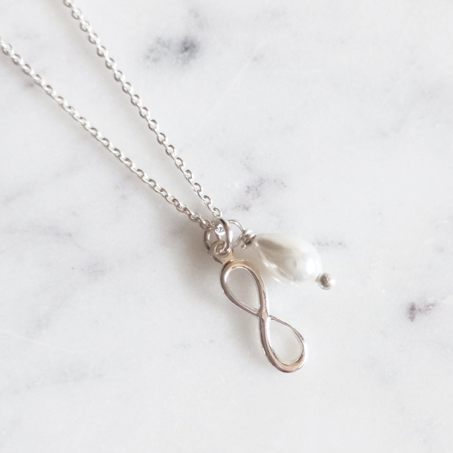 Dije Infinito de plata con perla